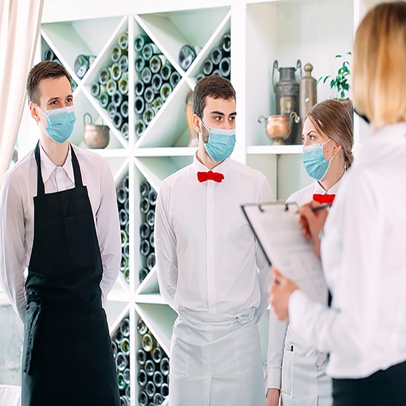 Employees of a Restaurant or Hotel in protective masks. End Of Quarantine. Restaurant Manager and his staff on the terrace. interaction with the chef in the restaurant